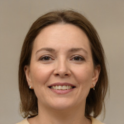 Joyful white adult female with medium  brown hair and brown eyes