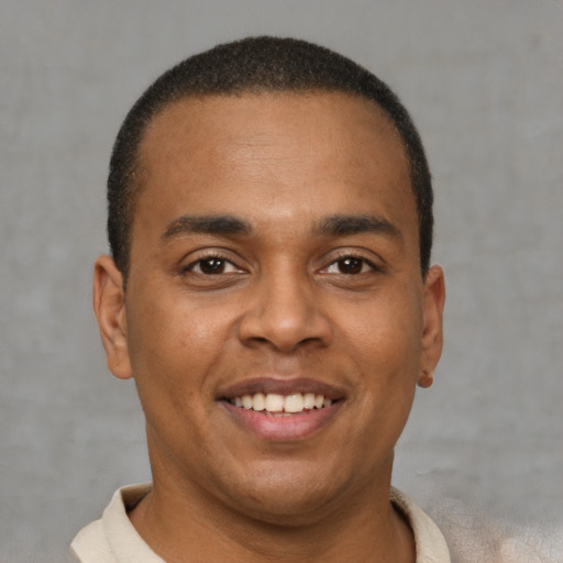 Joyful latino young-adult male with short  brown hair and brown eyes