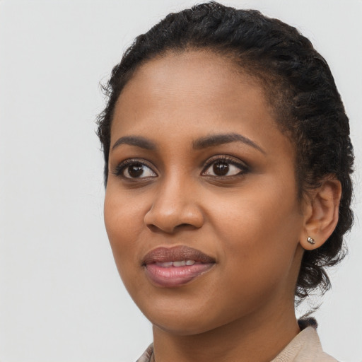Joyful black young-adult female with long  black hair and brown eyes