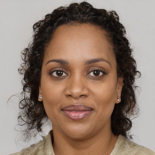 Joyful black young-adult female with long  brown hair and brown eyes