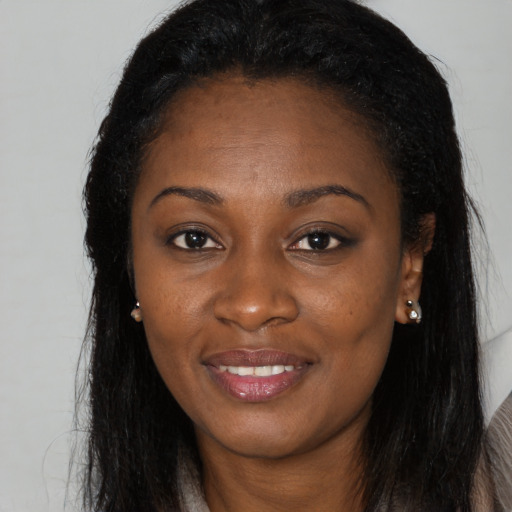 Joyful black young-adult female with long  brown hair and brown eyes