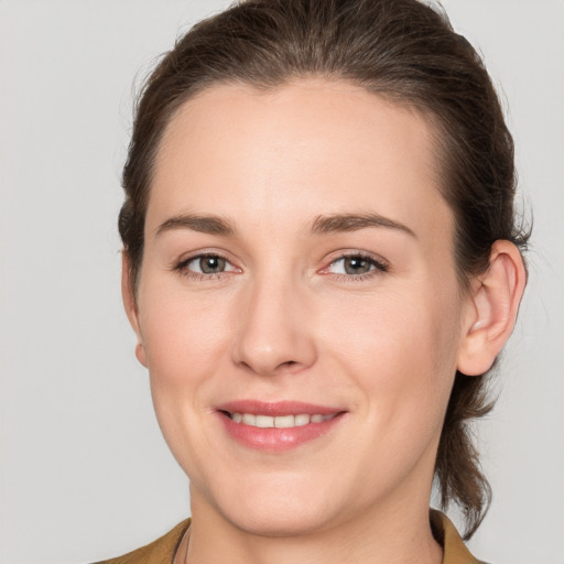 Joyful white young-adult female with medium  brown hair and grey eyes