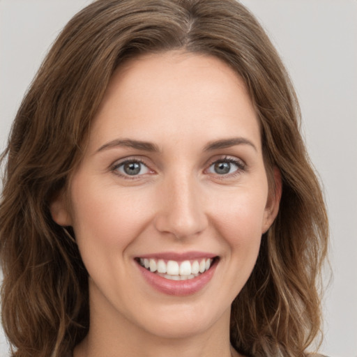 Joyful white young-adult female with long  brown hair and green eyes