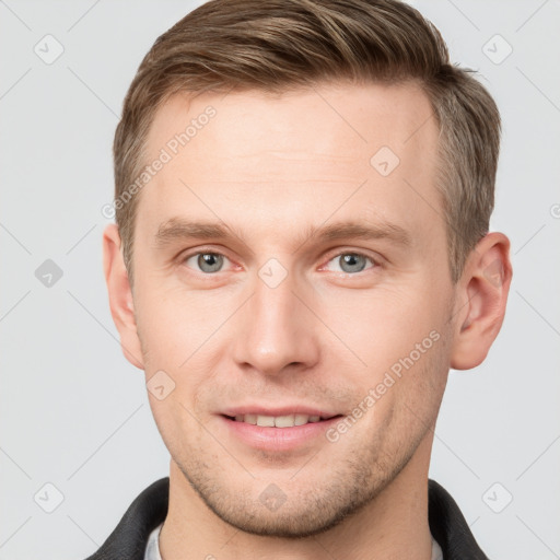 Joyful white young-adult male with short  brown hair and grey eyes