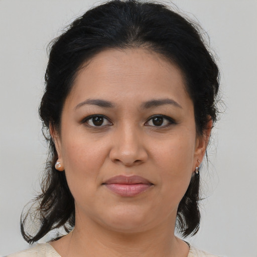 Joyful latino young-adult female with medium  brown hair and brown eyes