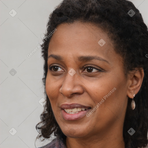 Joyful black adult female with long  brown hair and brown eyes