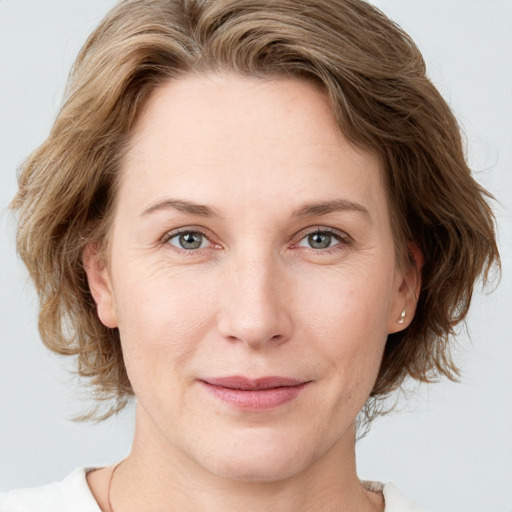 Joyful white young-adult female with medium  brown hair and blue eyes