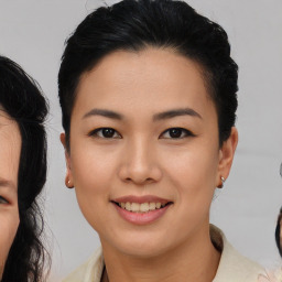 Joyful asian young-adult female with medium  black hair and brown eyes