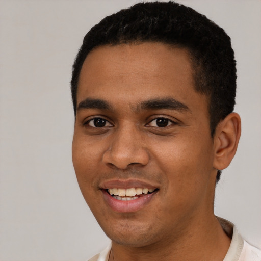 Joyful black young-adult male with short  black hair and brown eyes