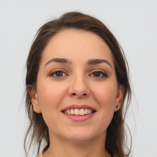 Joyful white young-adult female with medium  brown hair and grey eyes