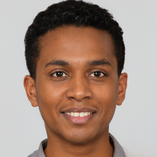 Joyful black young-adult male with short  black hair and brown eyes