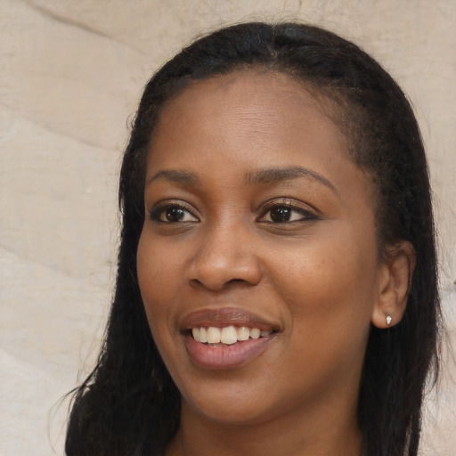Joyful black young-adult female with long  black hair and brown eyes