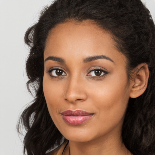 Joyful latino young-adult female with long  brown hair and brown eyes