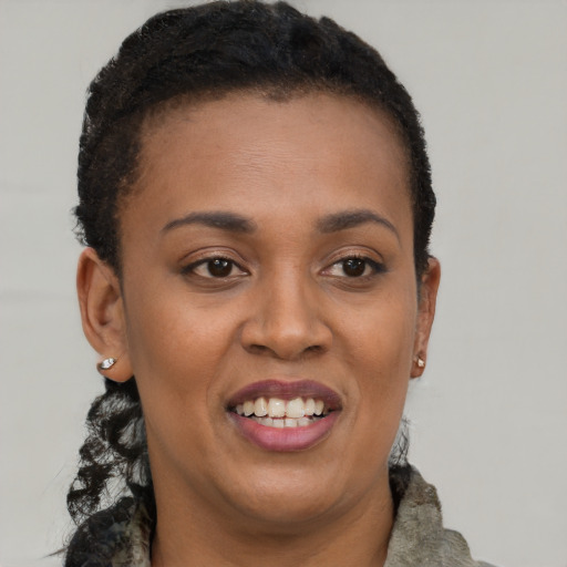 Joyful black young-adult female with short  brown hair and brown eyes