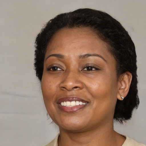 Joyful black adult female with medium  black hair and brown eyes