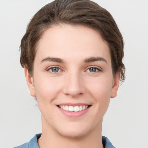 Joyful white young-adult female with short  brown hair and grey eyes