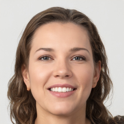 Joyful white young-adult female with medium  brown hair and grey eyes