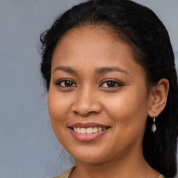 Joyful latino young-adult female with long  brown hair and brown eyes