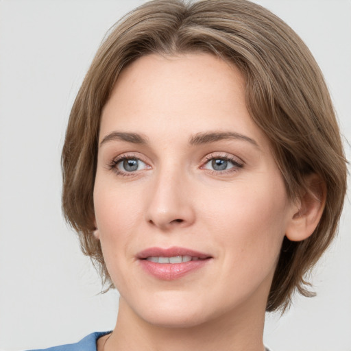 Joyful white young-adult female with medium  brown hair and green eyes