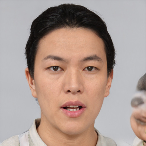 Joyful asian young-adult male with short  brown hair and brown eyes