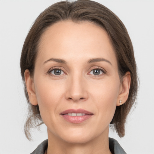 Joyful white adult female with medium  brown hair and grey eyes