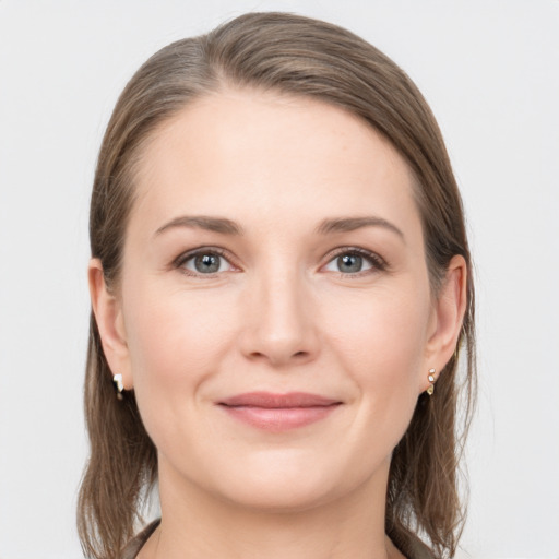 Joyful white young-adult female with medium  brown hair and grey eyes