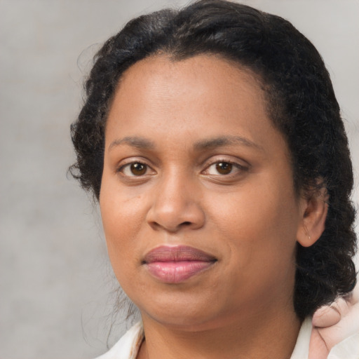 Joyful black adult female with medium  brown hair and brown eyes