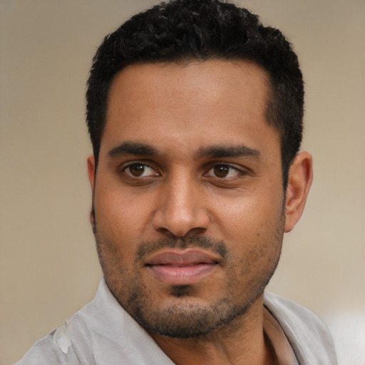 Joyful black young-adult male with short  black hair and brown eyes