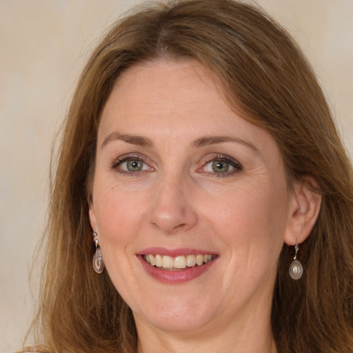 Joyful white adult female with long  brown hair and grey eyes