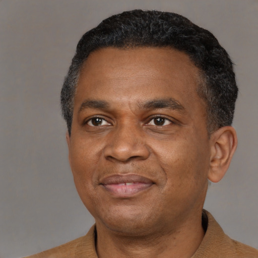Joyful black adult male with short  black hair and brown eyes