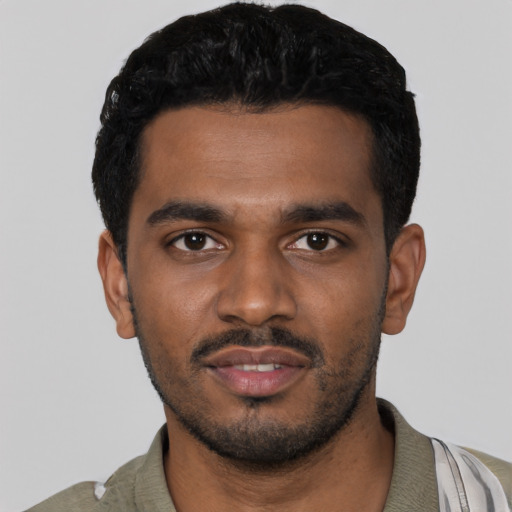 Joyful black young-adult male with short  black hair and brown eyes
