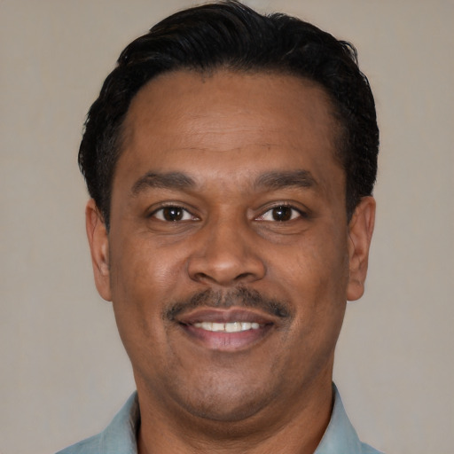 Joyful latino adult male with short  black hair and brown eyes