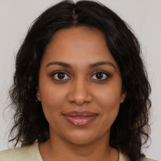 Joyful black young-adult female with medium  brown hair and brown eyes