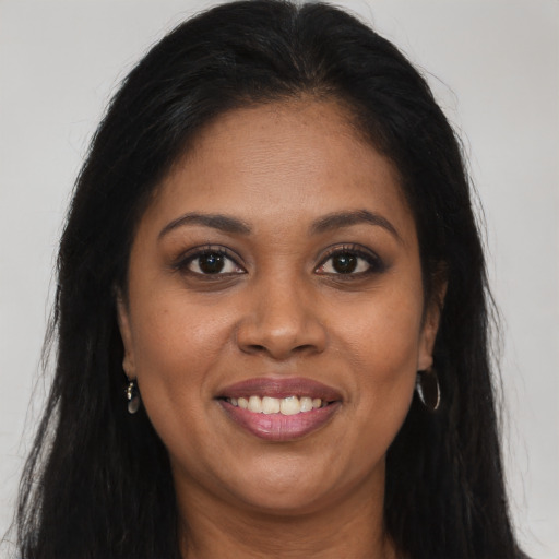 Joyful black young-adult female with long  brown hair and brown eyes