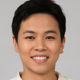 Joyful asian young-adult male with short  brown hair and brown eyes