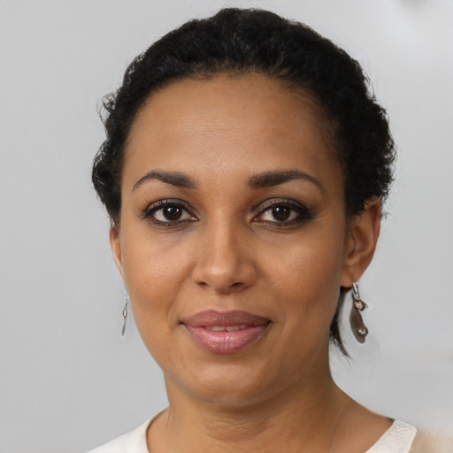 Joyful black adult female with short  black hair and brown eyes