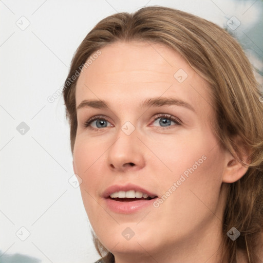 Joyful white young-adult female with long  brown hair and blue eyes