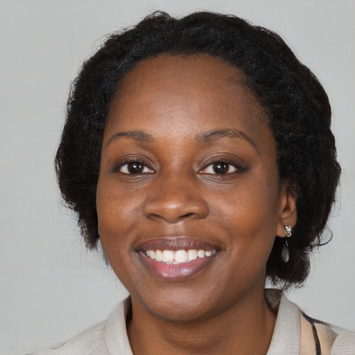 Joyful black adult female with medium  black hair and brown eyes