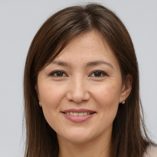 Joyful white adult female with long  brown hair and brown eyes
