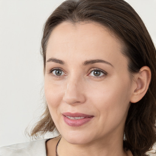 Joyful white young-adult female with medium  brown hair and grey eyes