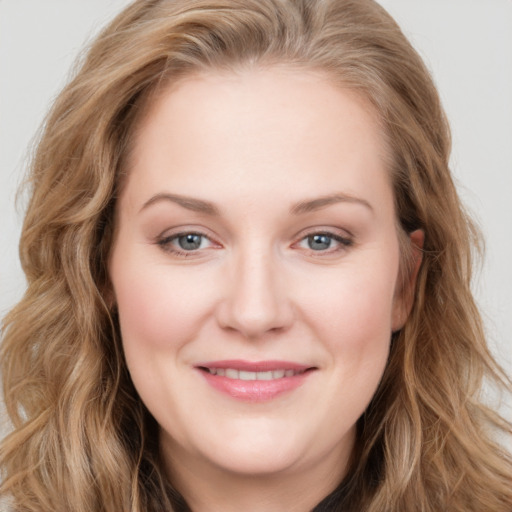 Joyful white young-adult female with long  brown hair and blue eyes