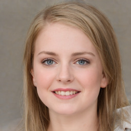 Joyful white young-adult female with long  brown hair and blue eyes