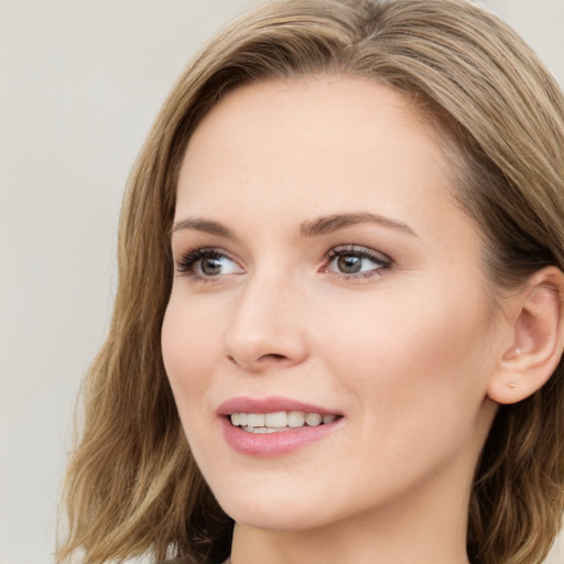 Joyful white young-adult female with long  brown hair and green eyes