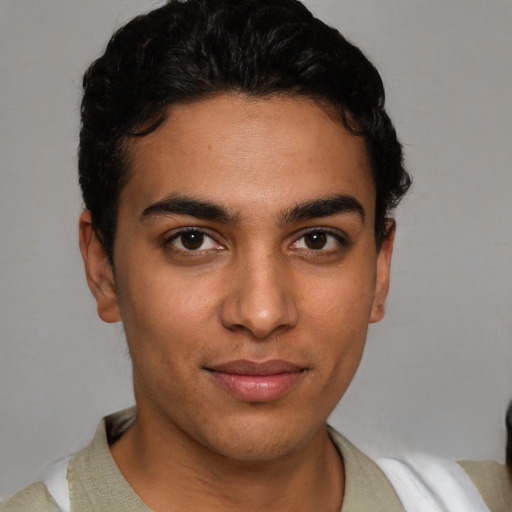 Joyful latino young-adult male with short  brown hair and brown eyes
