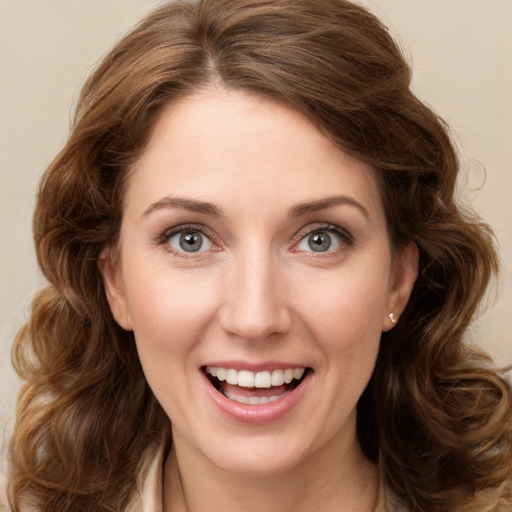 Joyful white young-adult female with long  brown hair and green eyes