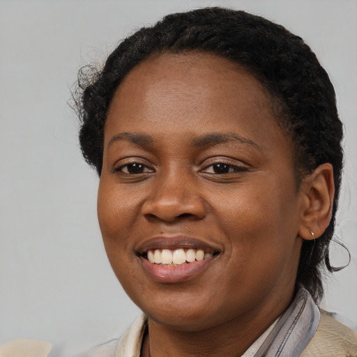 Joyful black young-adult female with short  brown hair and brown eyes