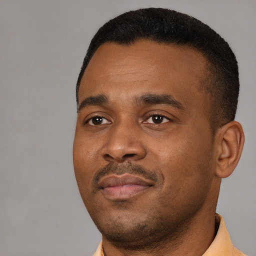 Joyful black young-adult male with short  black hair and brown eyes
