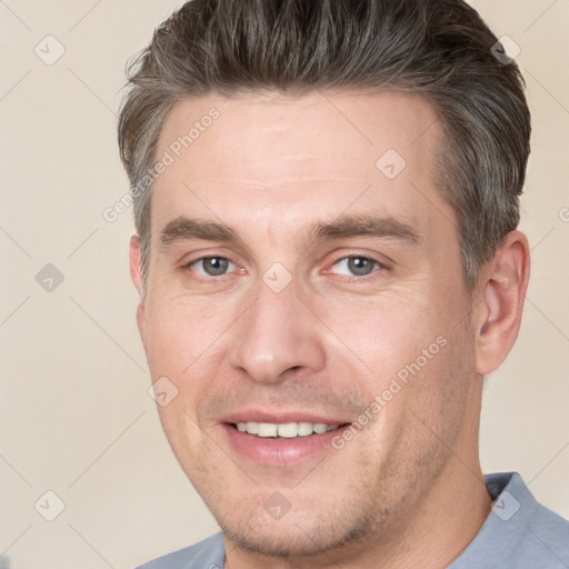 Joyful white adult male with short  brown hair and brown eyes