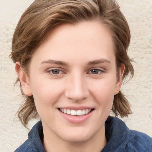 Joyful white young-adult female with medium  brown hair and blue eyes