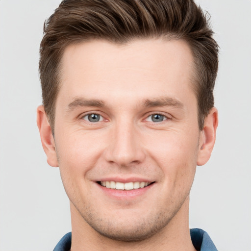 Joyful white young-adult male with short  brown hair and grey eyes